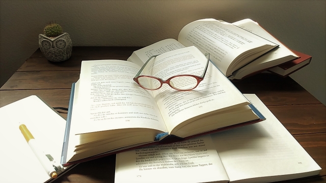 本とノートと眼鏡の写真